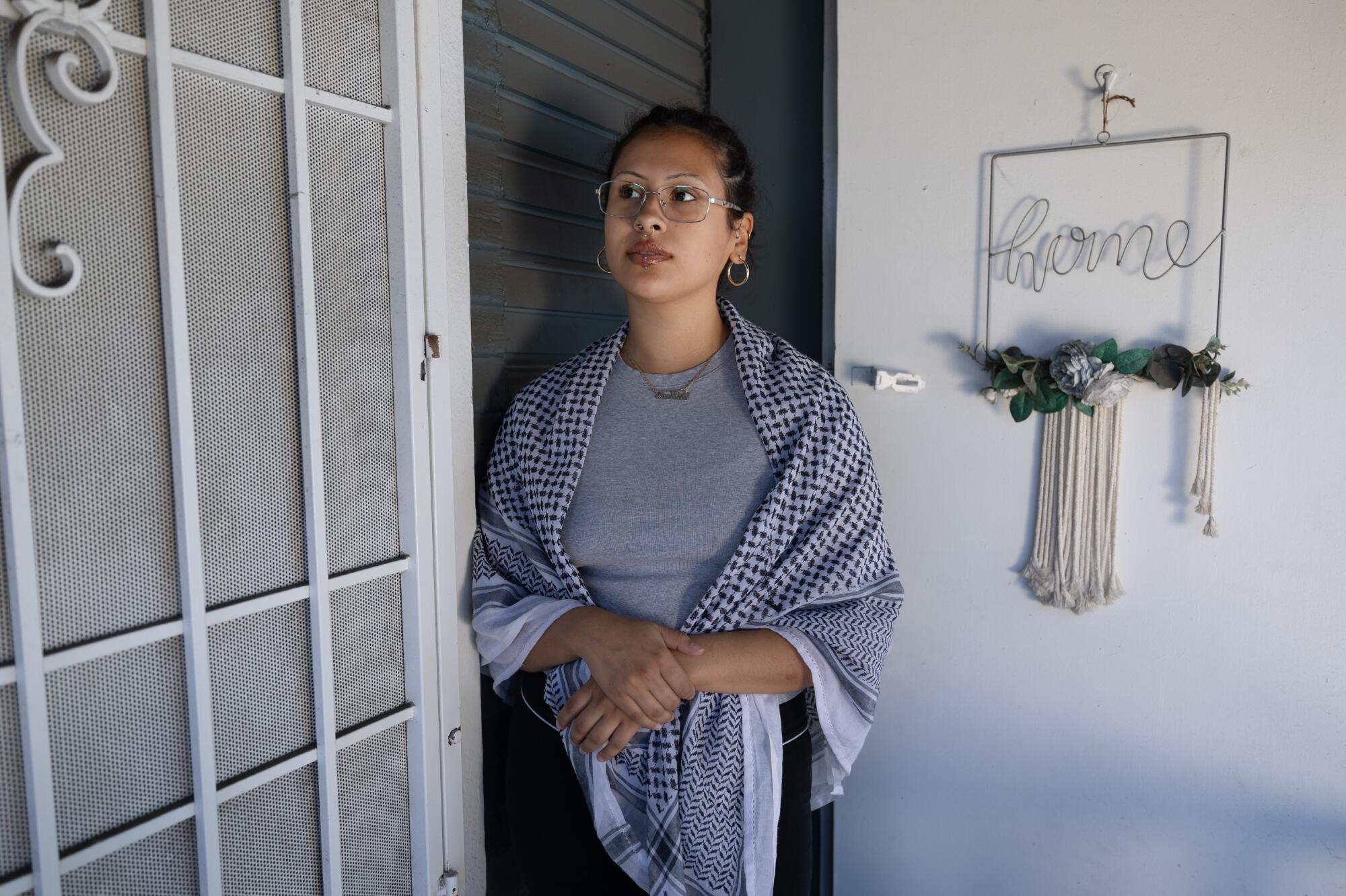 Una mujer está parada frente a la puerta. 