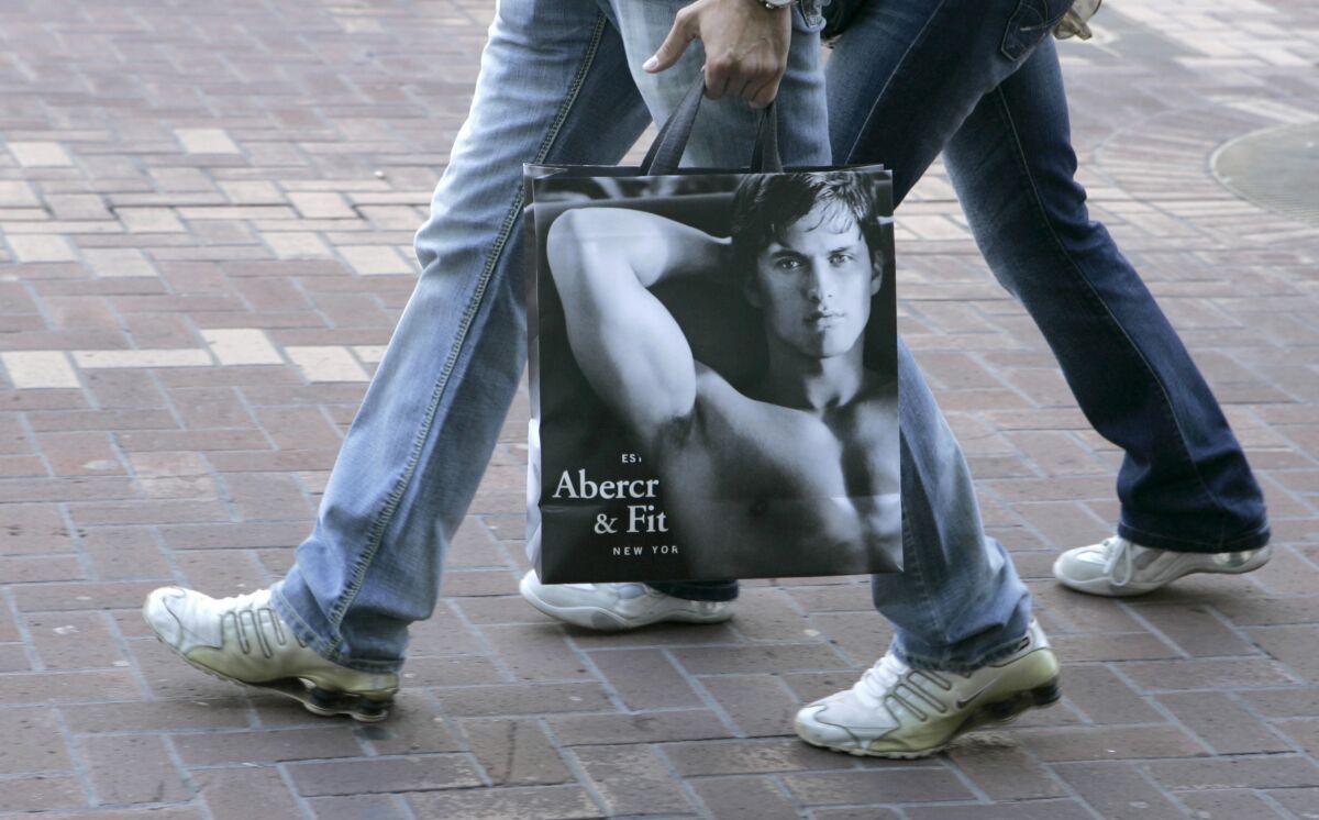 A pedestrian carries an Abercrombie & Fitch shopping bag.