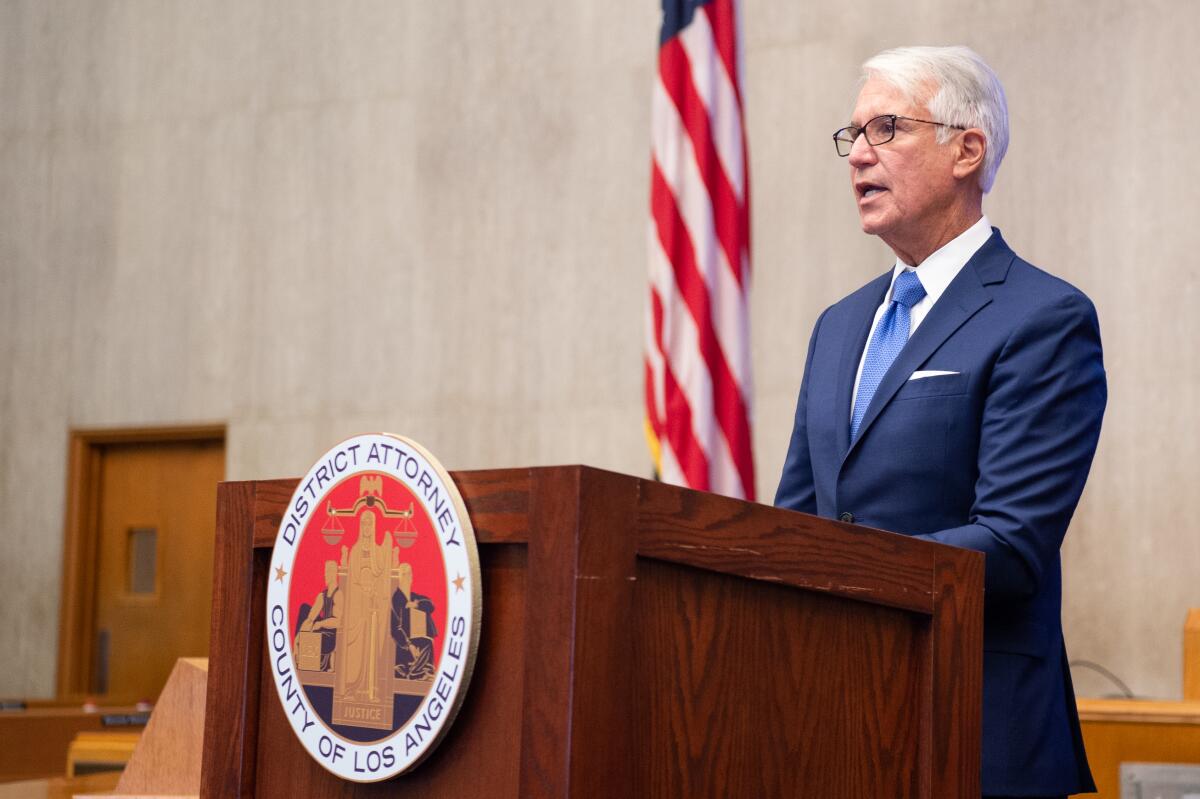 George Gascon at a lectern with the L.A. County district attorney seal