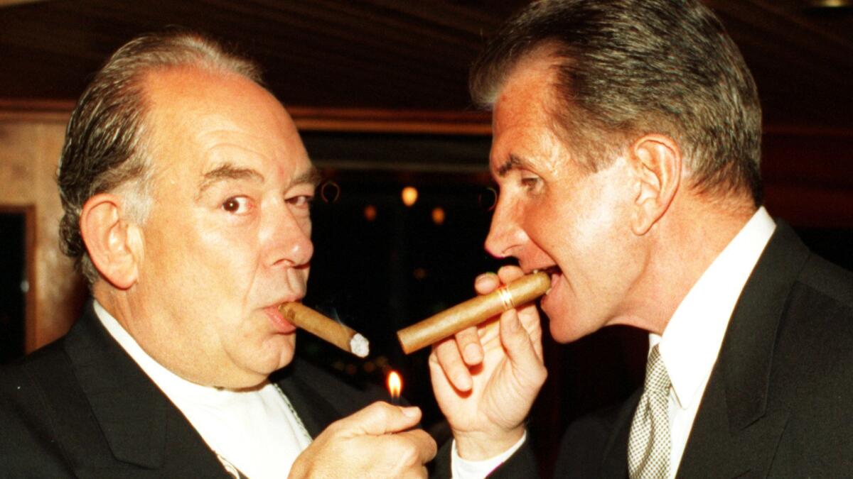 TV personality Robin Leach and actor George Hamilton puff on cigars during the James Beard Foundation of New York benefit.