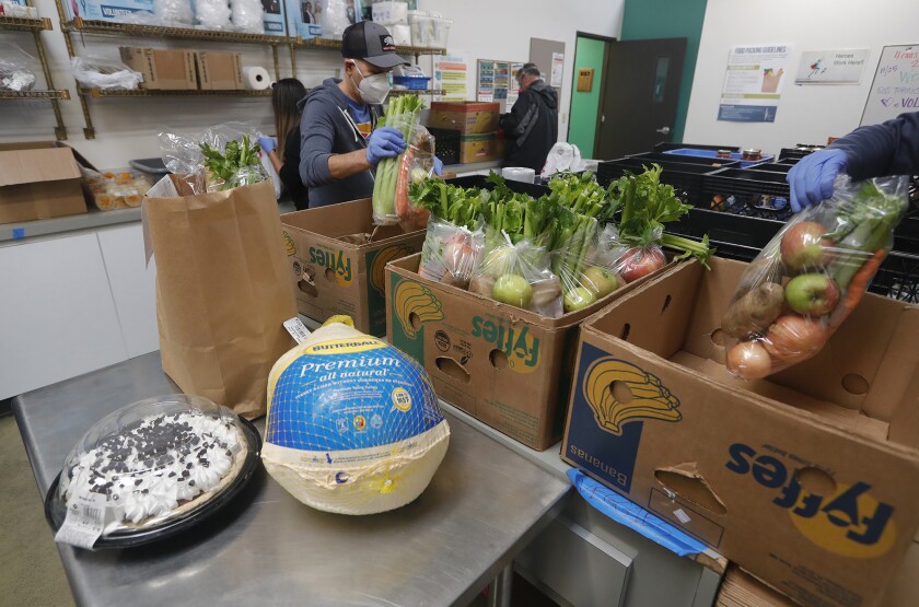 Volunteers gather bags of groceries to accommodate a meal for six.