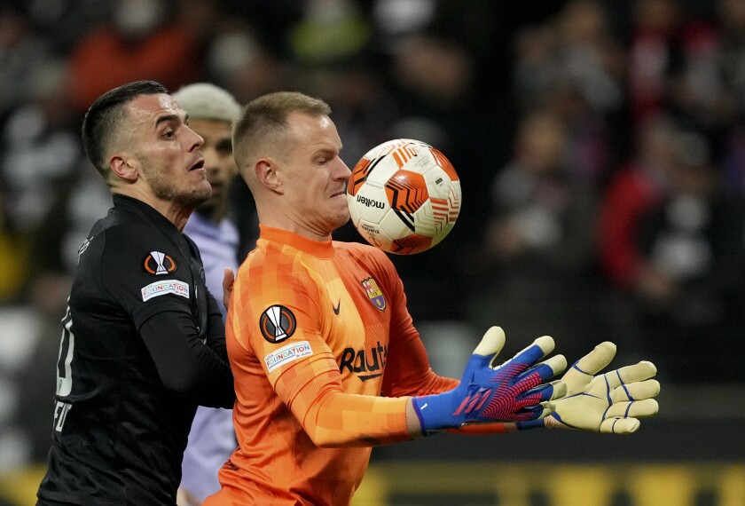 Barcelona's goalkeeper Marc-Andre ter Stegen, right, makes a save in front of Frankfurt's Filip Kostic on April 7