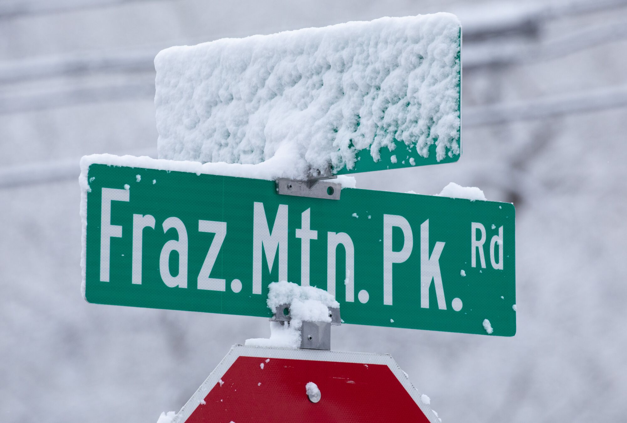 Snow accumulates on a street sign in Frazier Park