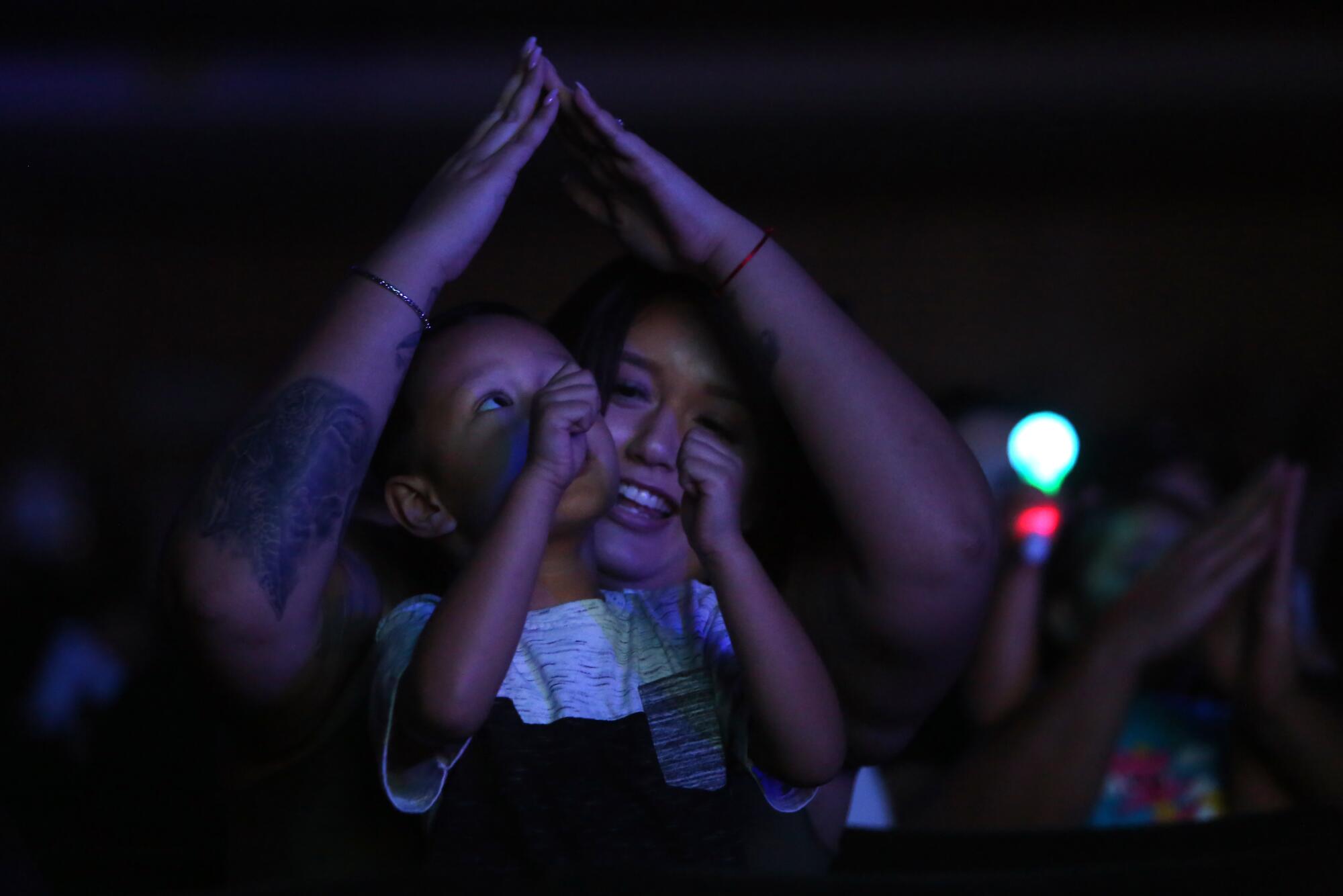 Three-year-old Julian Prum sings along with his mom, Jessica Maggart,