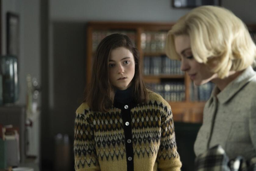 This image released by Neon shows Thomasin McKenzie, left, and Anne Hathaway in a scene from "Eileen." (Jeong Park/Neon via AP)