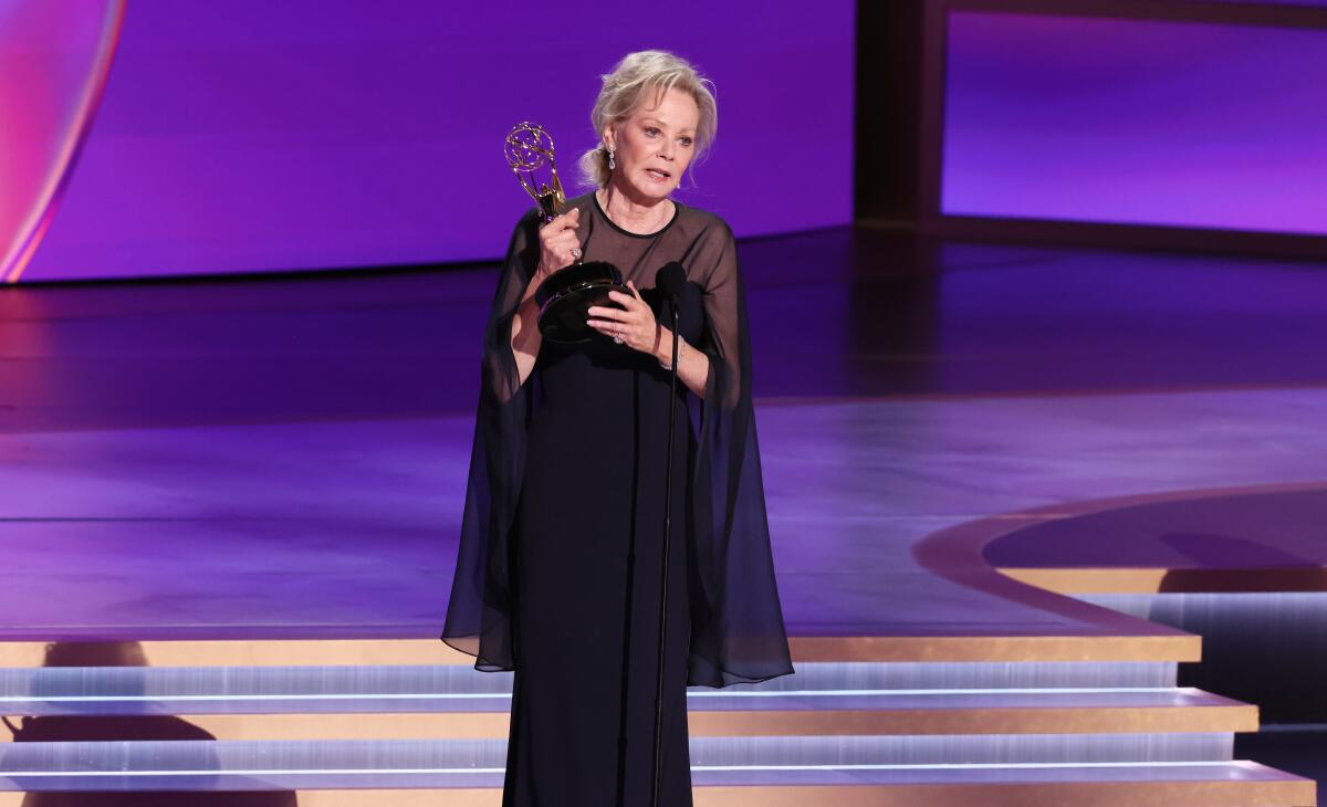 Jean Smart wears a black gown and holds her Emmy.