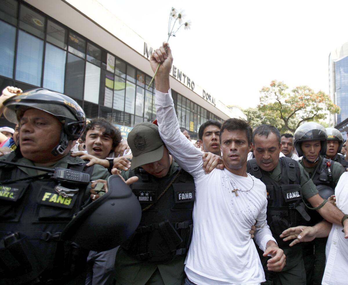 Archivo - En esta fotografía de archivo del 18 de febrero de 2014 el líder opositor venezolano Leopoldo López es escoltado por agentes de la Guardia Nacional Bolivariana en Caracas, Venezuela. López levantó el martes 23 de junio de 2015 la huelga de hambre que mantenía desde hace 30 días luego de que las autoridades electorales anunciaron la fecha de los comicios parlamentarios, una de las exigencias del opositor junto a la liberación de los presos políticos. (AP Foto/Alejandro Cegarra, Archivo)