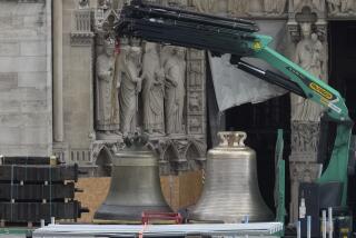 A truck carrying bells is parked outside Notre-Dame de Paris cathedral, in Paris, Thursday, Sept. 12, 204. A convoy of trucks bearing the restored bells pulled into the huge worksite surrounding the cathedral Thursday on an island in the Seine River. They will be blessed in a special ceremony inside the cathedral before being hoisted to hang in the monument's twin towers for the Dec. 8 reopening. (AP Photo/Michel Euler)