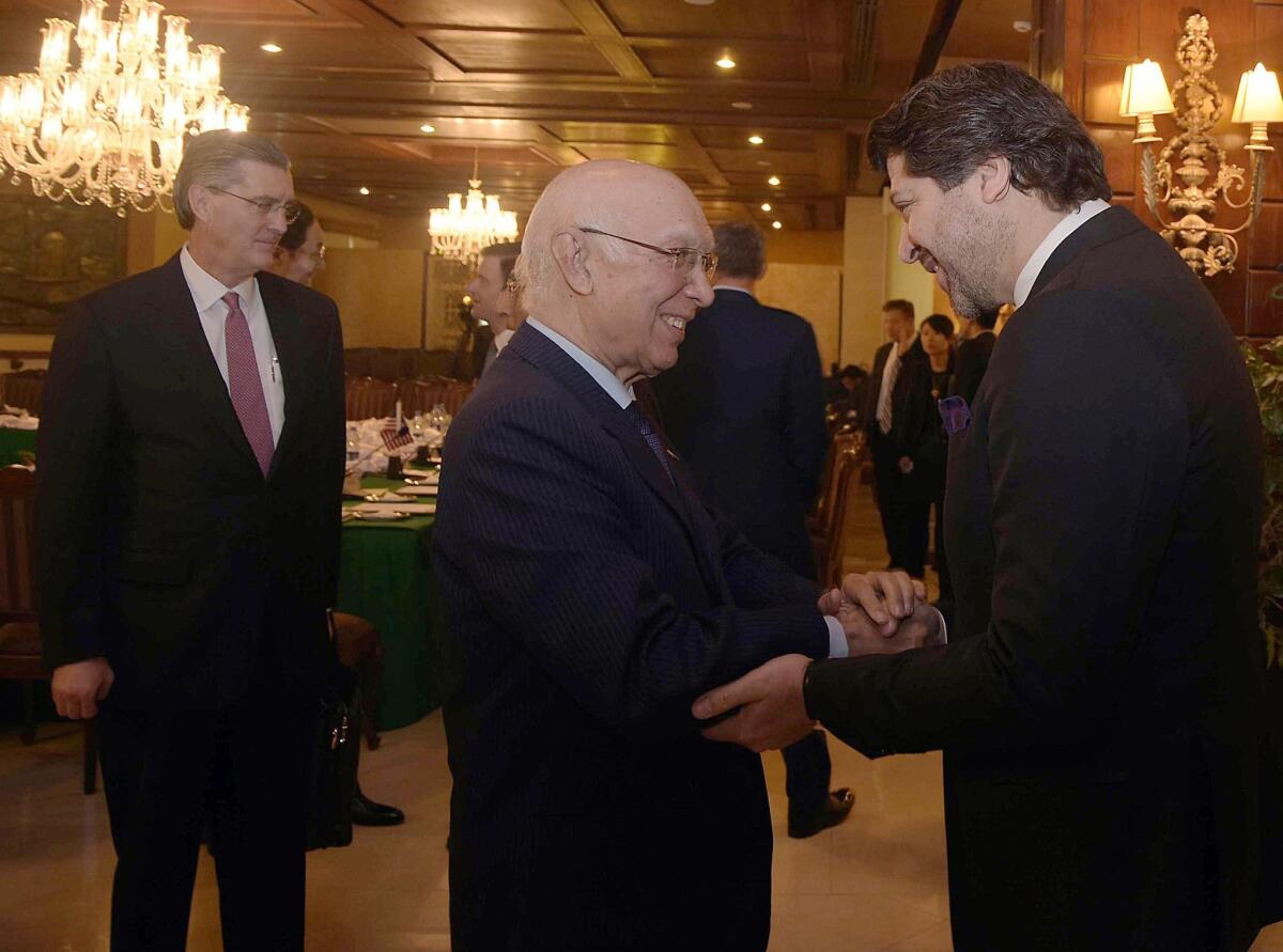 Pakistani national security advisor Sartaj Aziz, center, exchange greetings with Afghan Deputy Foreign Minister Hekmat Karzai at a meeting in Islamabad, Pakistan. Also attending the talks is U.S. envoy Richard G. Olson, left.