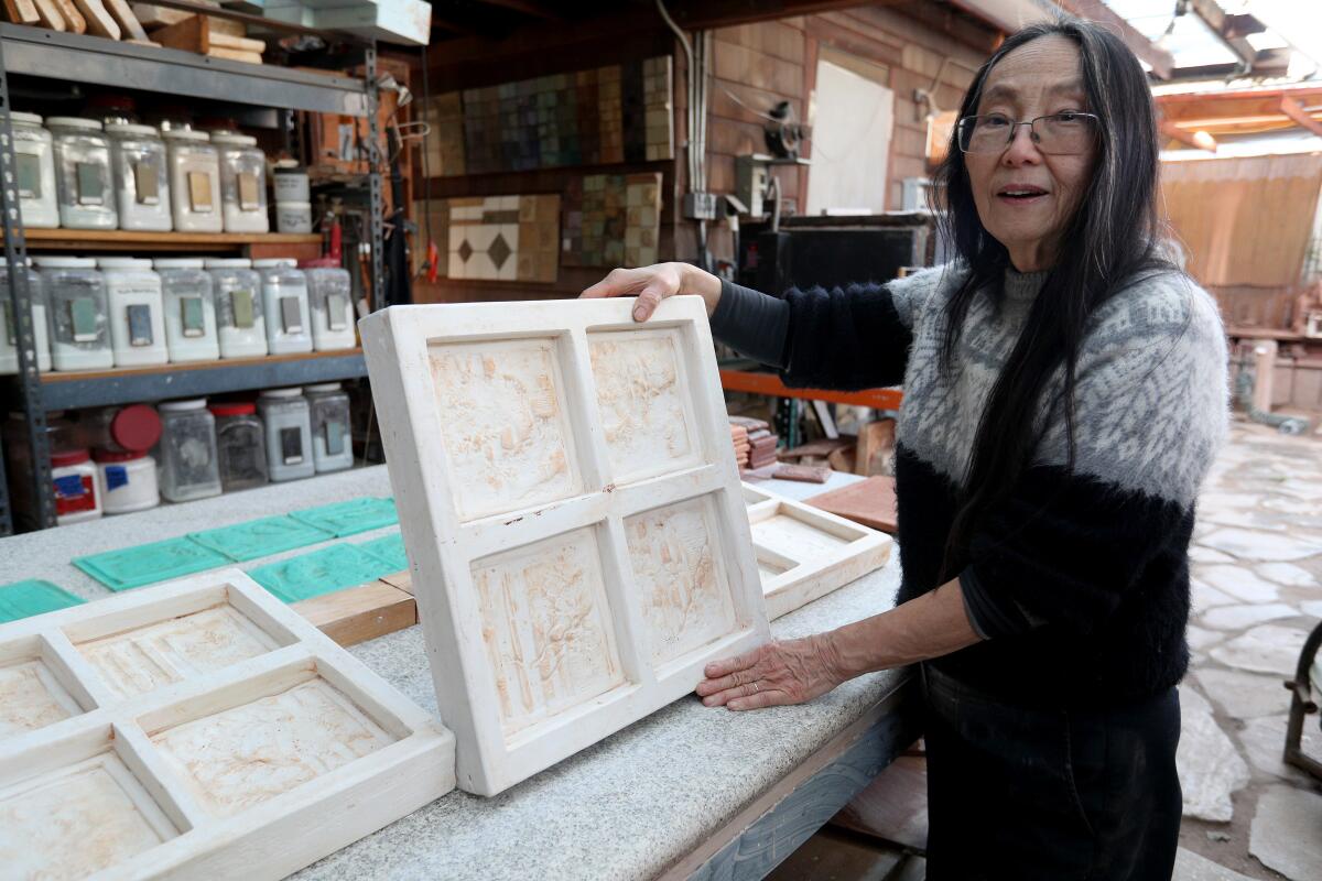Tile artist Cha-Rie Tang shows some of the molds she created that she will use to recreate an Arts-and-Crafts- era tile fireplace that sits in a La Cañada building owned by the school district.