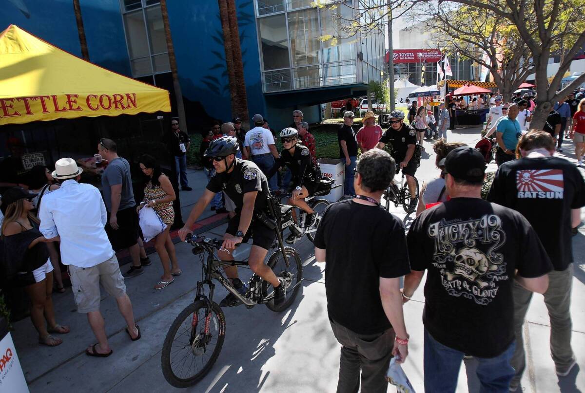 Long Beach police officers ride bikes through the crowd on Friday, the first day of the three-day Toyota Grand Prix of Long Beach.