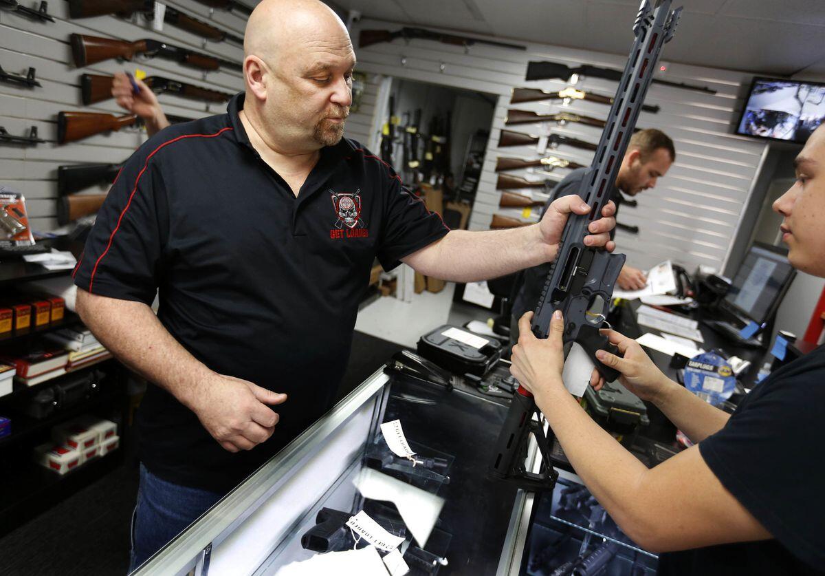 Terry McGuire, owner of the Get Loaded gun store in Grand Terrace in San Bernardino County, shows a customer a Cobalt Kinetics BAMF rifle.