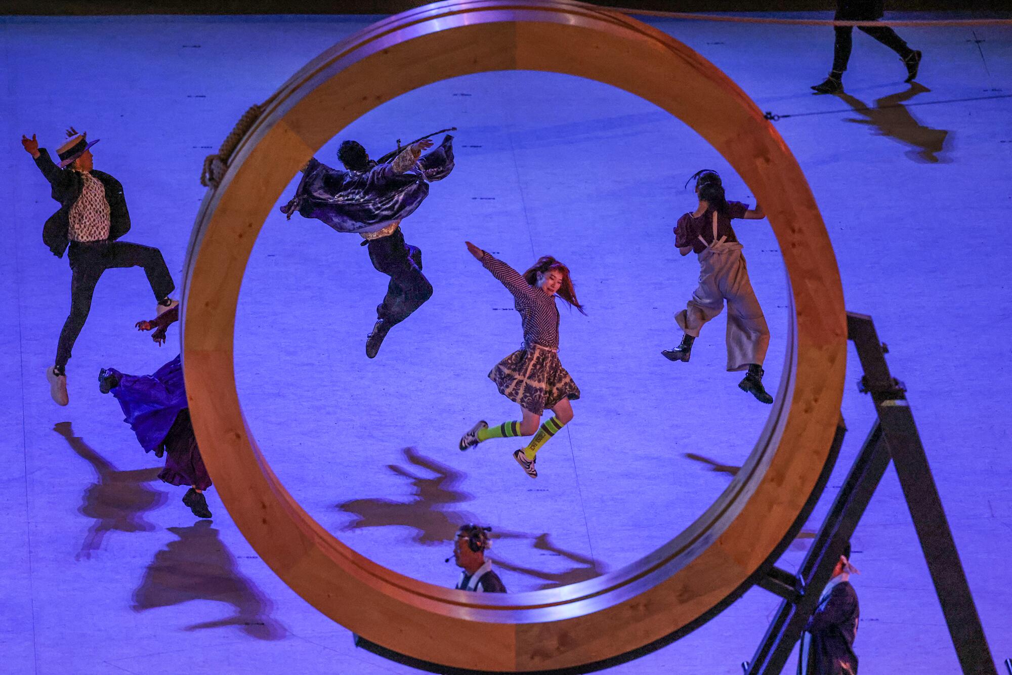 Dancers are framed inside an Olympic ring