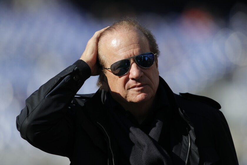 Chargers chairman Dean Spanos walks on the football field, his hand on his head