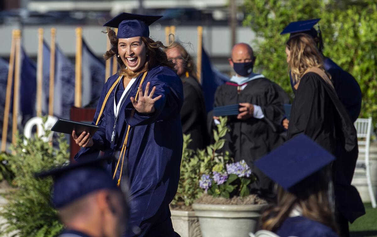 Penelope Klein waves after receiving her diploma during the Newport Harbor 2021 graduation ceremony.