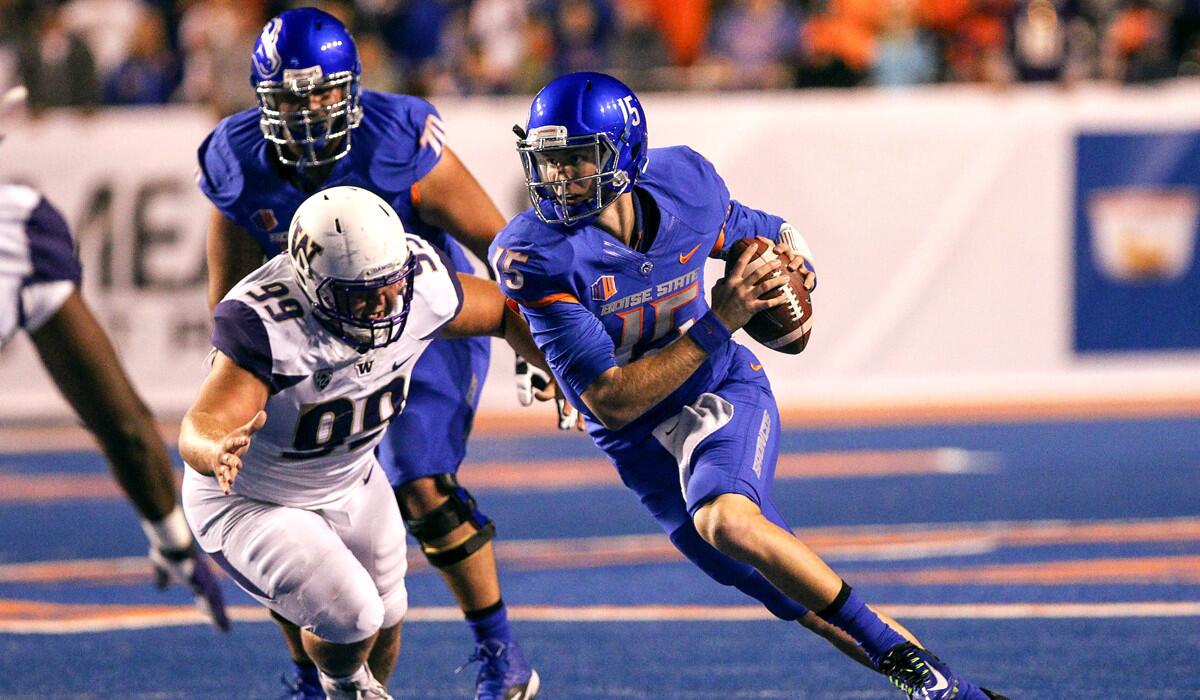 Boise State quarterback Ryan Finley scrambles past Washington defensive lineman Greg Gaines during football action on Friday.