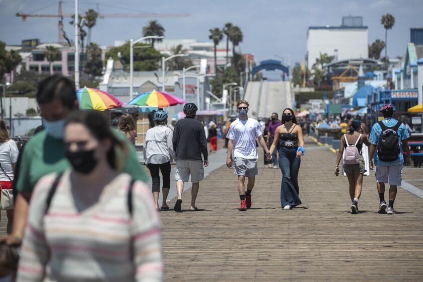 SANTA MONICA, CA - JUNE 29, 2020: People wear protective face covering against the coronavirus while walking on the Santa Monica Pier on June 29, 2020. L.A. County is expected to reach 100,000 cases of coronavirus.(Mel Melcon / Los Angeles Times)