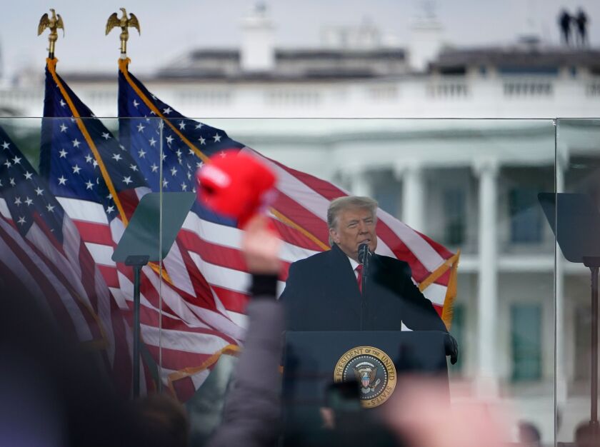 President Trump speaks at a podium next to American flags.
