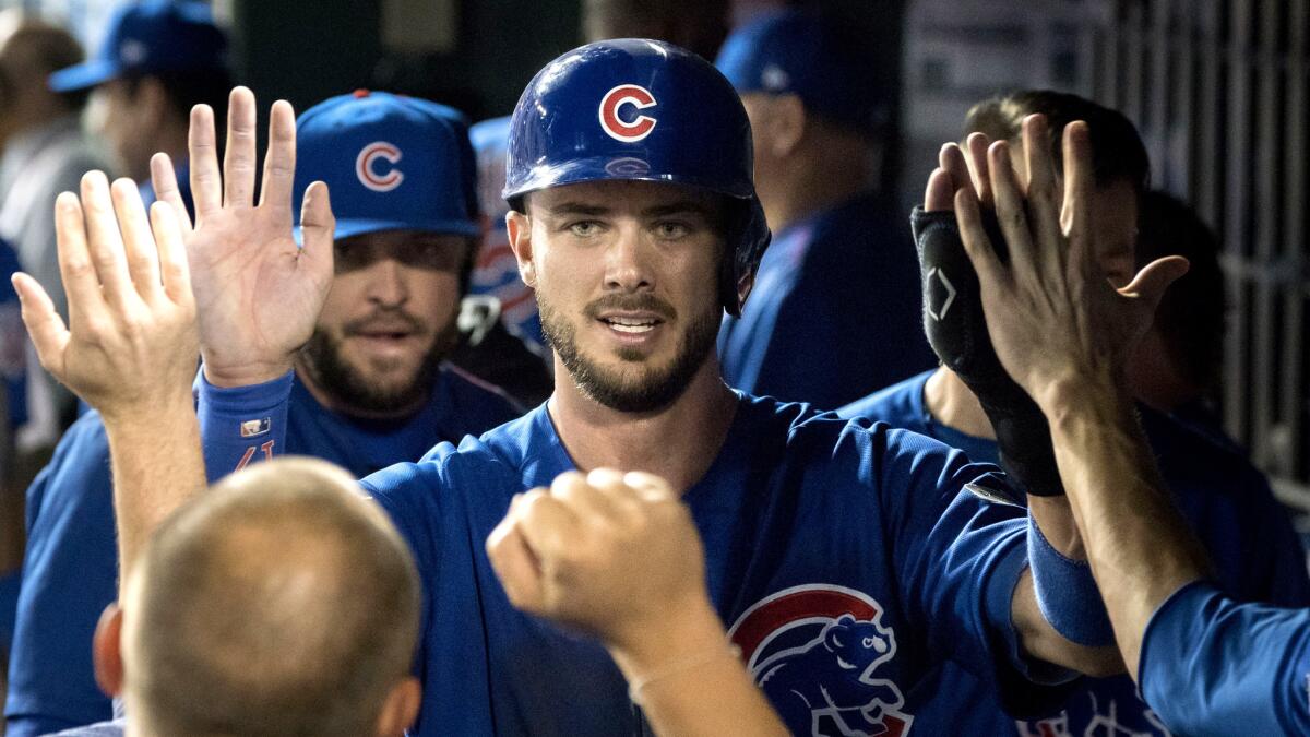 Cubs third baseman Kris Bryant is congratulated by teammates after scoring a run against the Nationals during the sixth inning Friday.