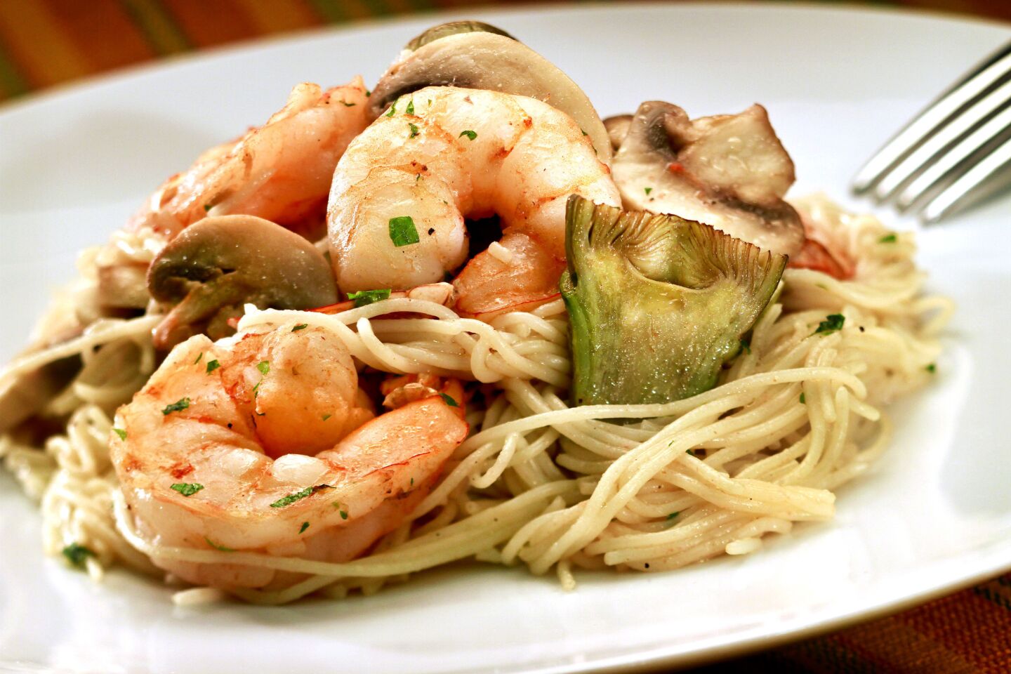 Fresh and bright with large shrimp, tomatoes, mushrooms, garlic and a sprinkling of fresh parsley, capellini al gamberetti, a pasta dish from Napoli restaurant in Loma Linda, doesn't get any easier. Make it in less than 30 minutes.