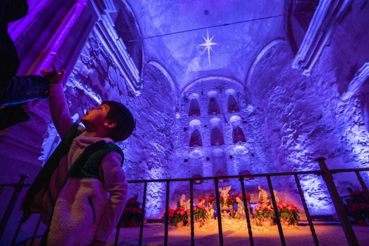 Ryan Hartley, 3, of Mission Viejo, views the Nativity in the Ruins of the Great Stone Church up close during the opening ceremony of the Capistrano Lights, Mission San Juan Capistrano's annual holiday event.