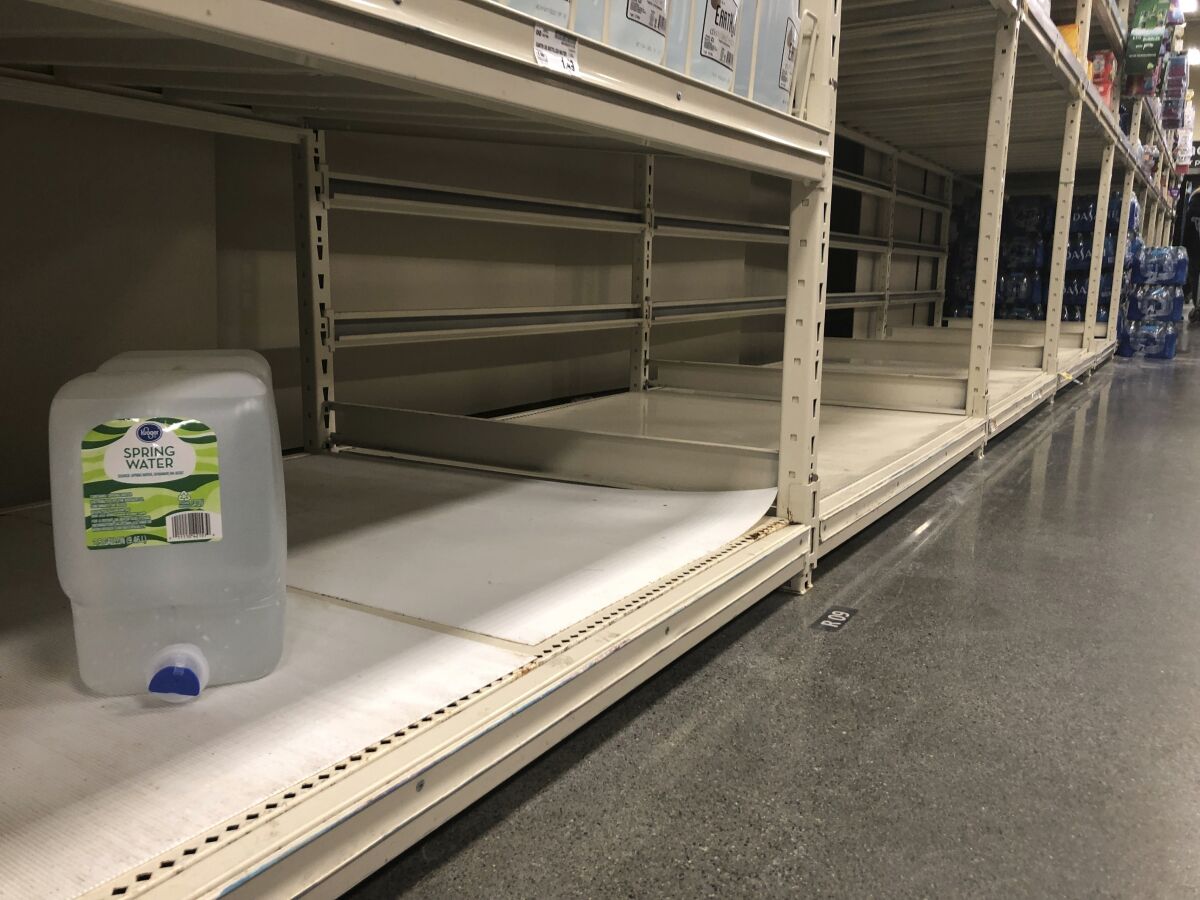Un contenedor de agua en una estantería vacía en un supermercado en Anchorage, Alaska, el domingo 1 de marzo de 2020. (AP Foto/Mark Thiessen)