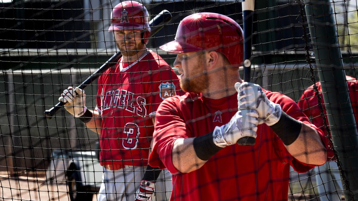 Angels outfielder Kole Calhoun takes live batting practice before teammate Craig Gentry (3) on Sunday in Tempe, Ariz.