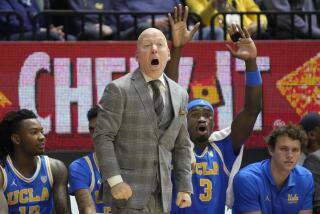UCLA coach Mick Cronin and players on the bench behind him react to call during the Bruins' win at Cal