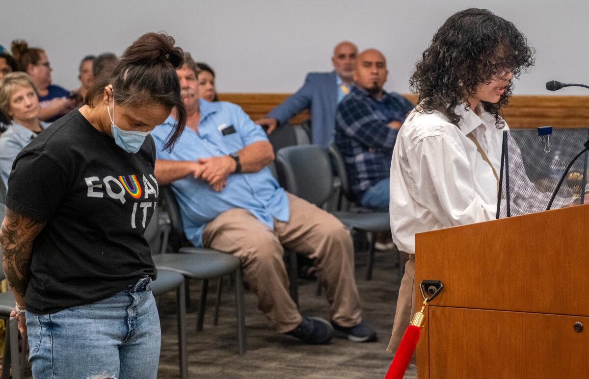 Ruqayyah Stoller, left, stands behind child, Celeste, at a school board meeting in Murrieta Valley Unified. 