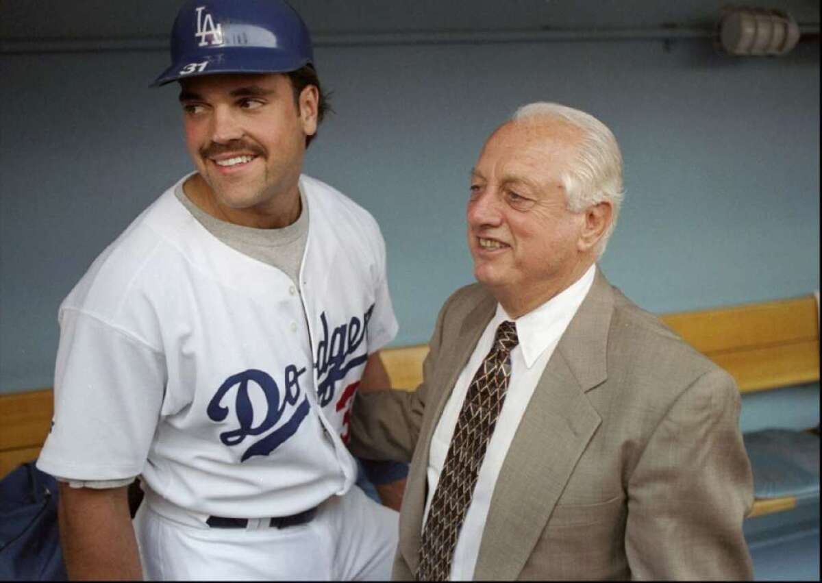 Mike Piazza stands with Tommy Lasorda in the Dodgers dugout in 1997.