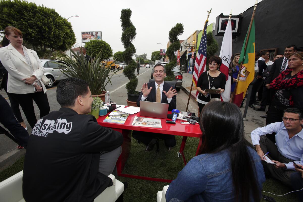 Los Angeles Mayor Eric Garcetti meets Armando Gonzalez, 39, and Leslie Baez, 20, of Soul Skating at his "help desk" temporarily set up on 1842 E. 1st St. in Boyle Heights.