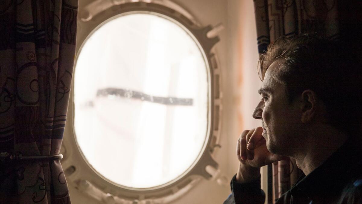 "Darkest Hour" film editor Valerio Bonelli looks out a porthole on the Queen Mary in Long Beach. Winston Churchill once traveled aboard the ship.