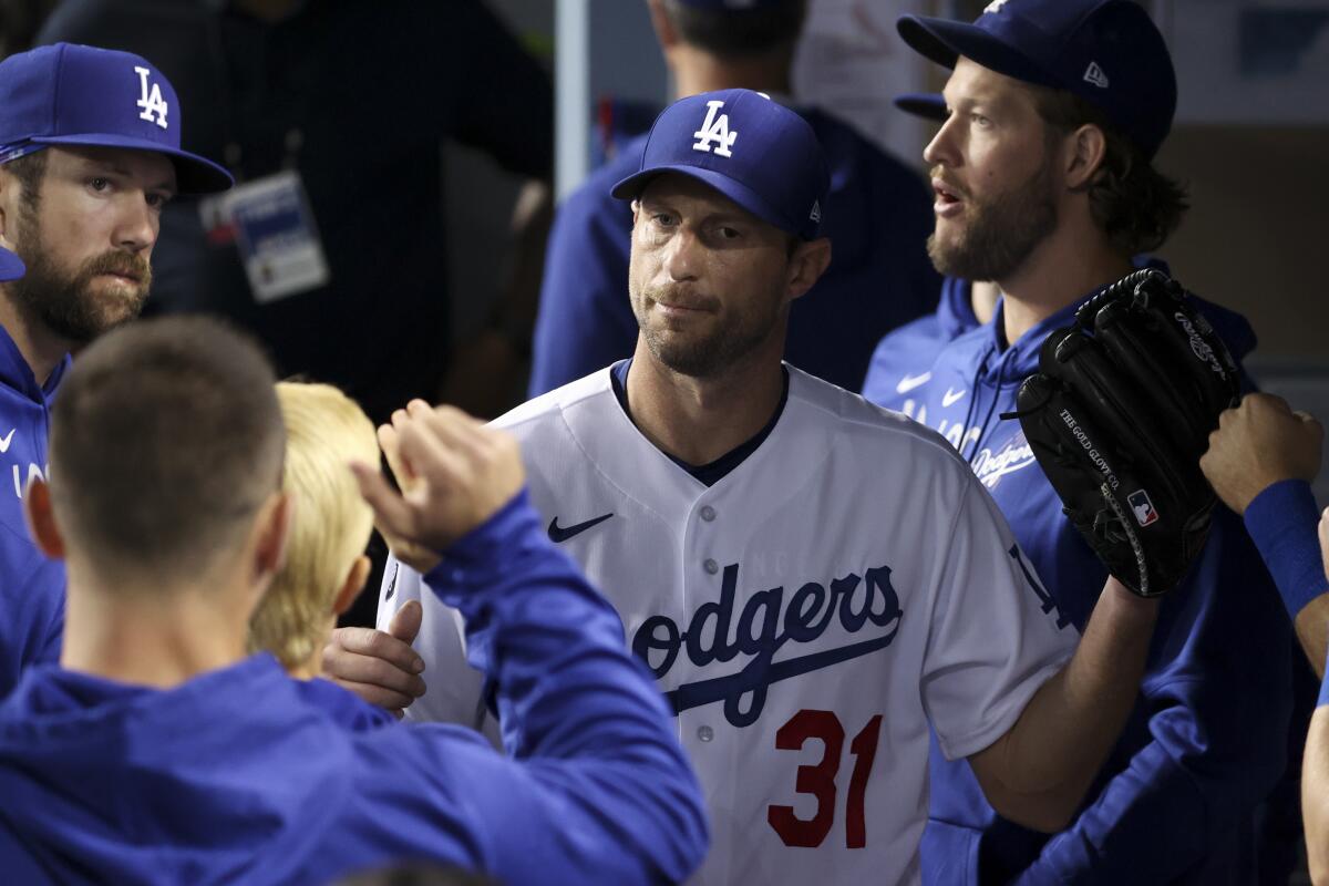 Dodgers pitcher Max Scherzer walks in the dugout after being pulled in the fifth inning.