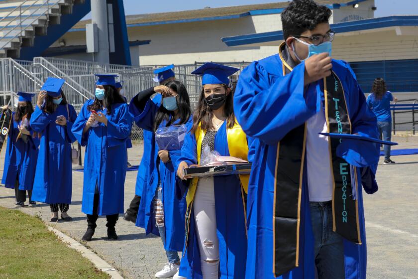 High school seniors from Chula Vista High School lined up near the end zone where many of them got dressed in their cap and gown for their graduation event on the school's football.