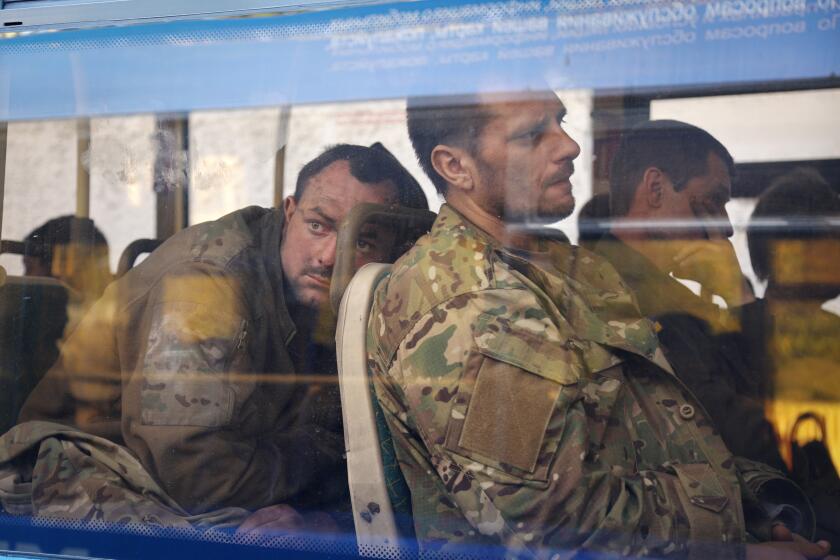 Ukrainian servicemen sit in a bus after they were evacuated from the besieged Mariupol's Azovstal steel plant, near a remand prison in Olyonivka, in territory under the government of the Donetsk People's Republic, eastern Ukraine, Tuesday, May 17, 2022. More than 260 fighters, some severely wounded, were pulled from a steel plant on Monday that is the last redoubt of Ukrainian fighters in the city and transported to two towns controlled by separatists, officials on both sides said. (AP Photo/Alexei Alexandrov)