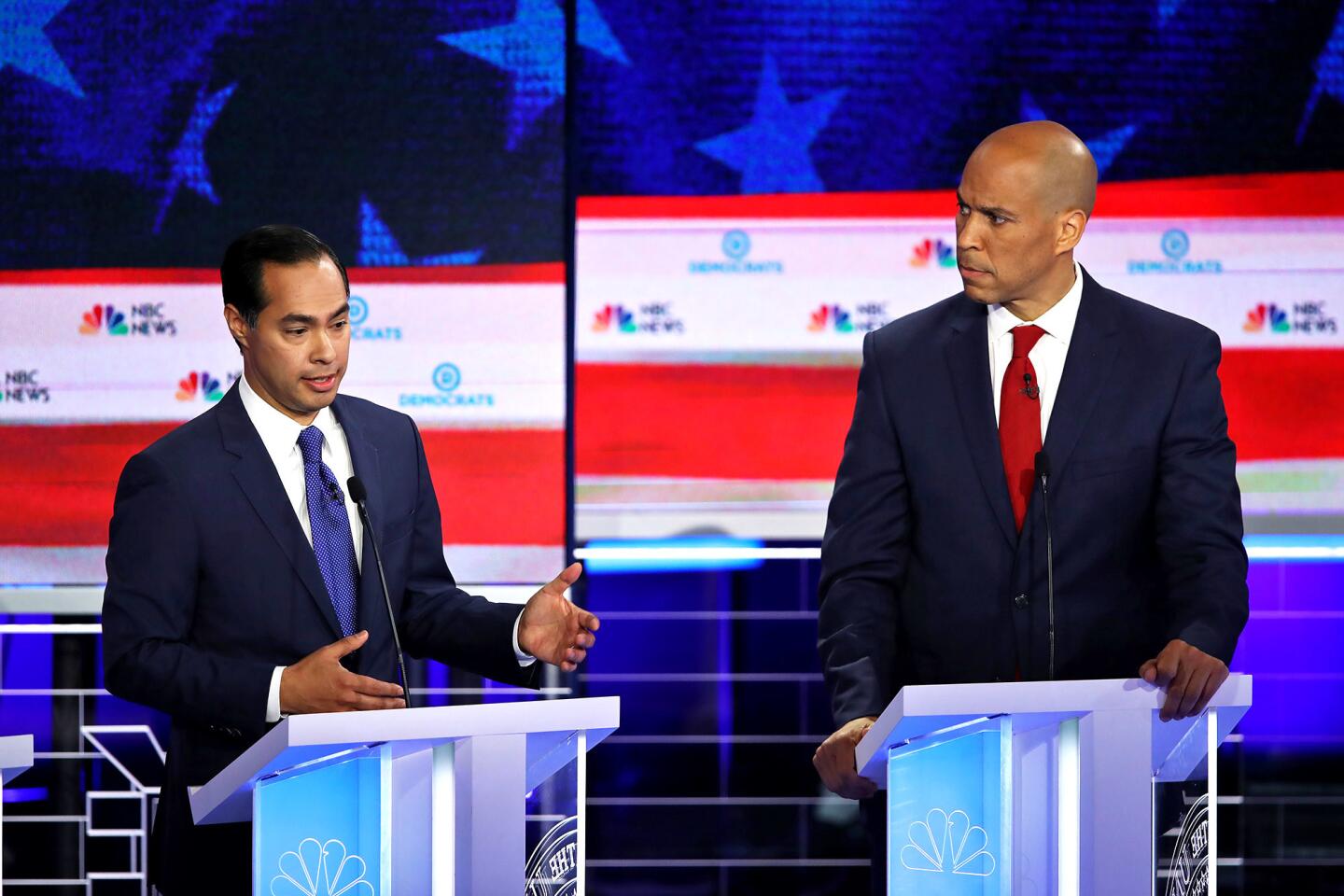 Cory Booker listens as Julián Castro speaks Wednesday night.