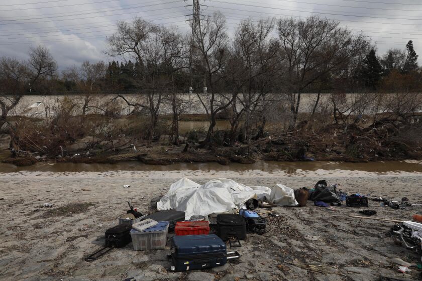 LOS ANGELES, CA - FEBRUARY 1, 2019 - - A homeless persons belongings are left above the Los Angeles River on February 1, 2019. Many homeless who live on an island, background, in the middle of the river move to higher ground before a storm arrives. The homeless who live along the river remember their fellow homeless friend Geoff Garland who was killed late last year in a murder suicide in Atwater Village. (Genaro Molina/Los Angeles Times)