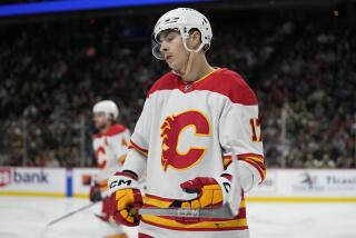 Calgary Flames center Yegor Sharangovich, front, reacts after a tripping penalty called on the Flames during the third period of an NHL hockey game against the Minnesota Wild, Thursday, Dec. 14, 2023, in St. Paul, Minn. (AP Photo/Abbie Parr)