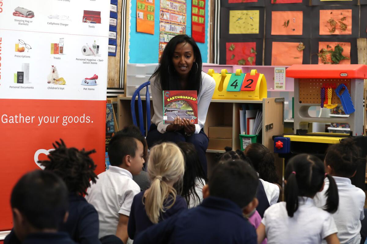 A teacher reads to elementary school students in a classroom