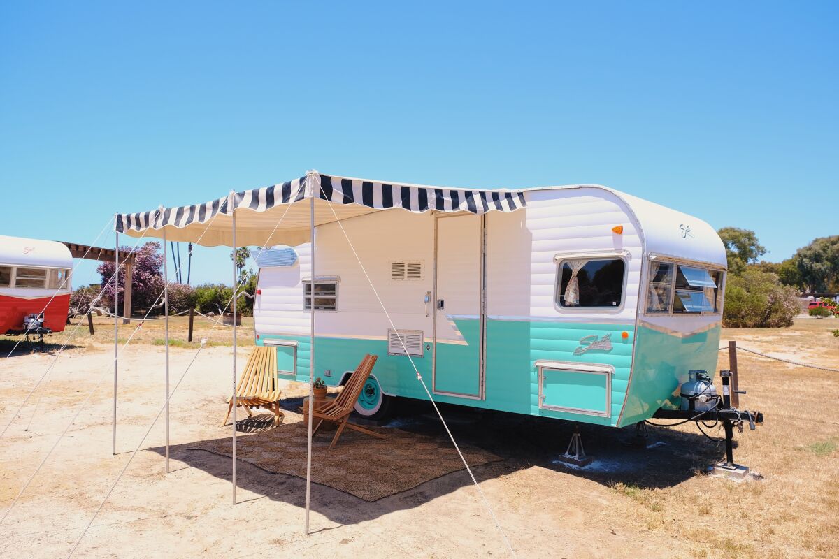An old-fashioned trailer with an awning.