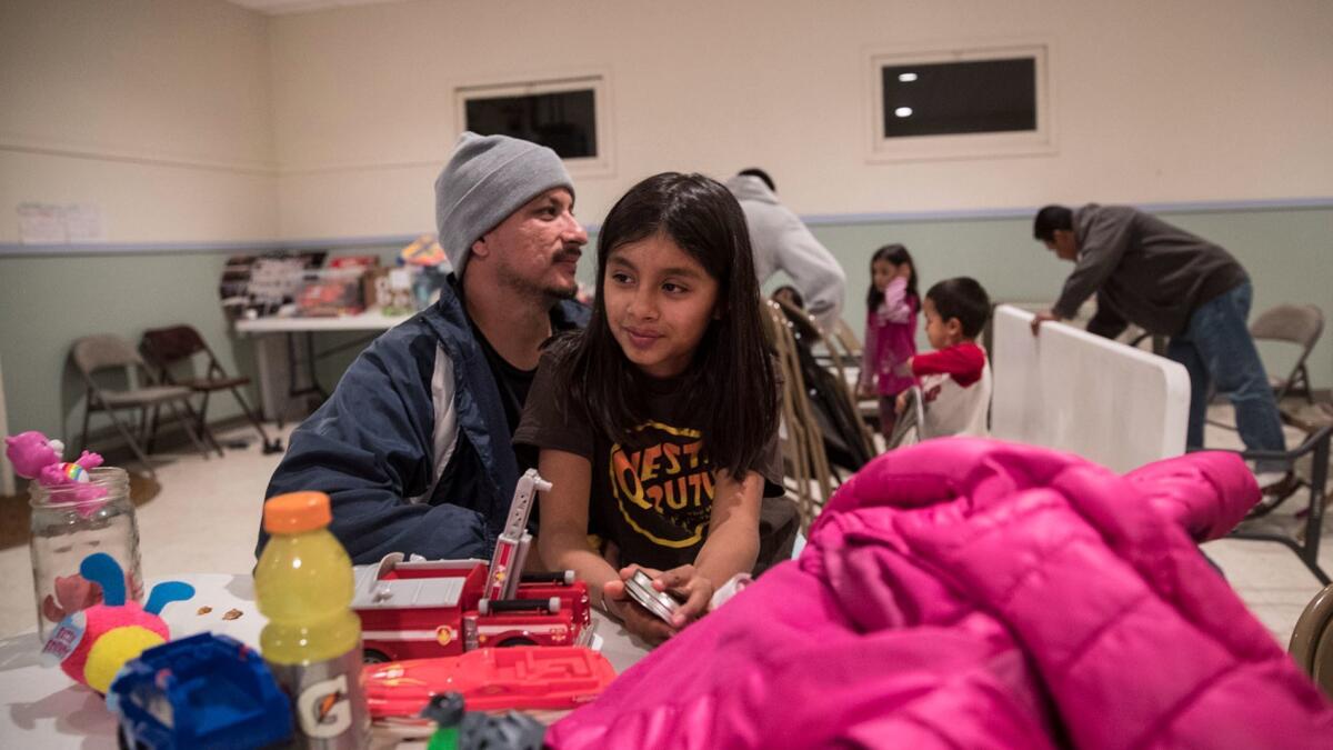 Ashley Vasquez, 11, and her father Sergio Vasquez relax after dinner at the Bodega Bay Grange community hall. Services are available for people displaced by the devastating fires.