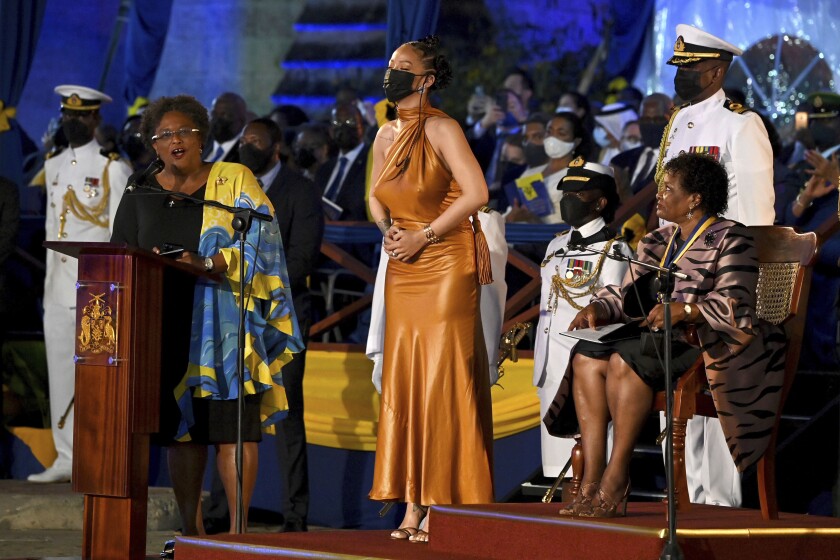 Barbados' Prime Minister Mia Mottley, left, and President of Barbados, Dame Sandra Mason, right, honour Rihanna as a National Hero, during the Presidential Inauguration Ceremony, at Heroes Square, in Bridgetown, Barbados, Tuesday, Nov. 30, 2021. Barbados has stopped pledging allegiance to Queen Elizabeth II as it shed another vestige of its colonial past and became a republic for the first time in history. Several leaders, dignitaries and artists, including Prince Charles, attended a ceremony that began late Monday and stretched into Tuesday in a popular square where the statue of a well-known British lord was removed last year amid a worldwide push to erase symbols of oppression. (Jeff J Mitchell PA via AP)