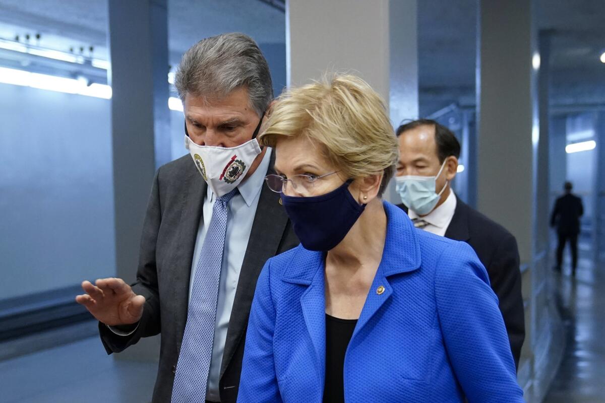 Sen. Joe Manchin (D-W.Va.) speaks with Sen. Elizabeth Warren (D-Mass.) on Capitol Hill 