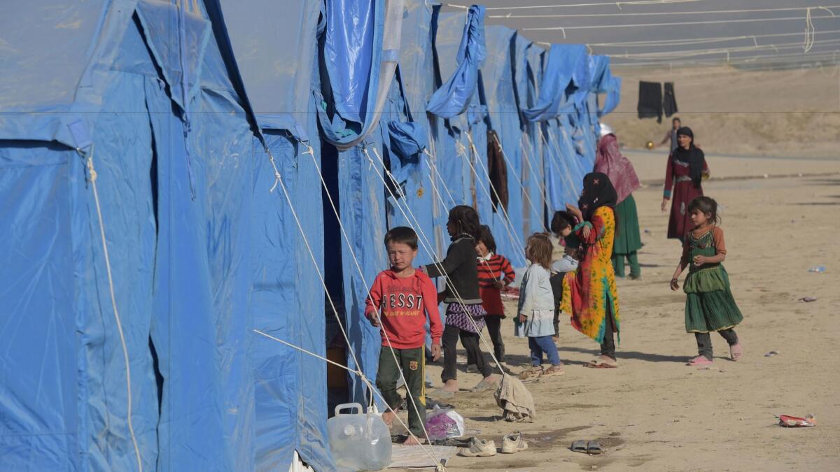 Children displaced by fighting between Afghan forces and Taliban insurgents stay in a camp on the Kabul outskirts.