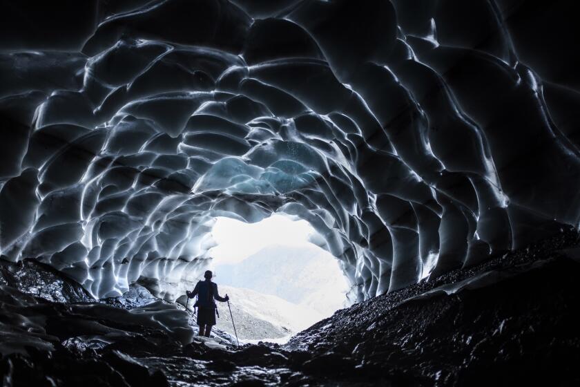 FILE - A man stands in a glacier cave at the Sardona glacier, July 27, 2022, in Vaettis, Switzerland. The melting glacier has revealed a cave. Faced with increasing demand for alpine water resources at a time of accelerating glacier melt, policymakers from 8 European countries are meeting in Switzerland to prevent a dispute over diminishing water resources from the highest peaks in the Alps. (Gian Ehrenzeller/Keystone via AP, File)
