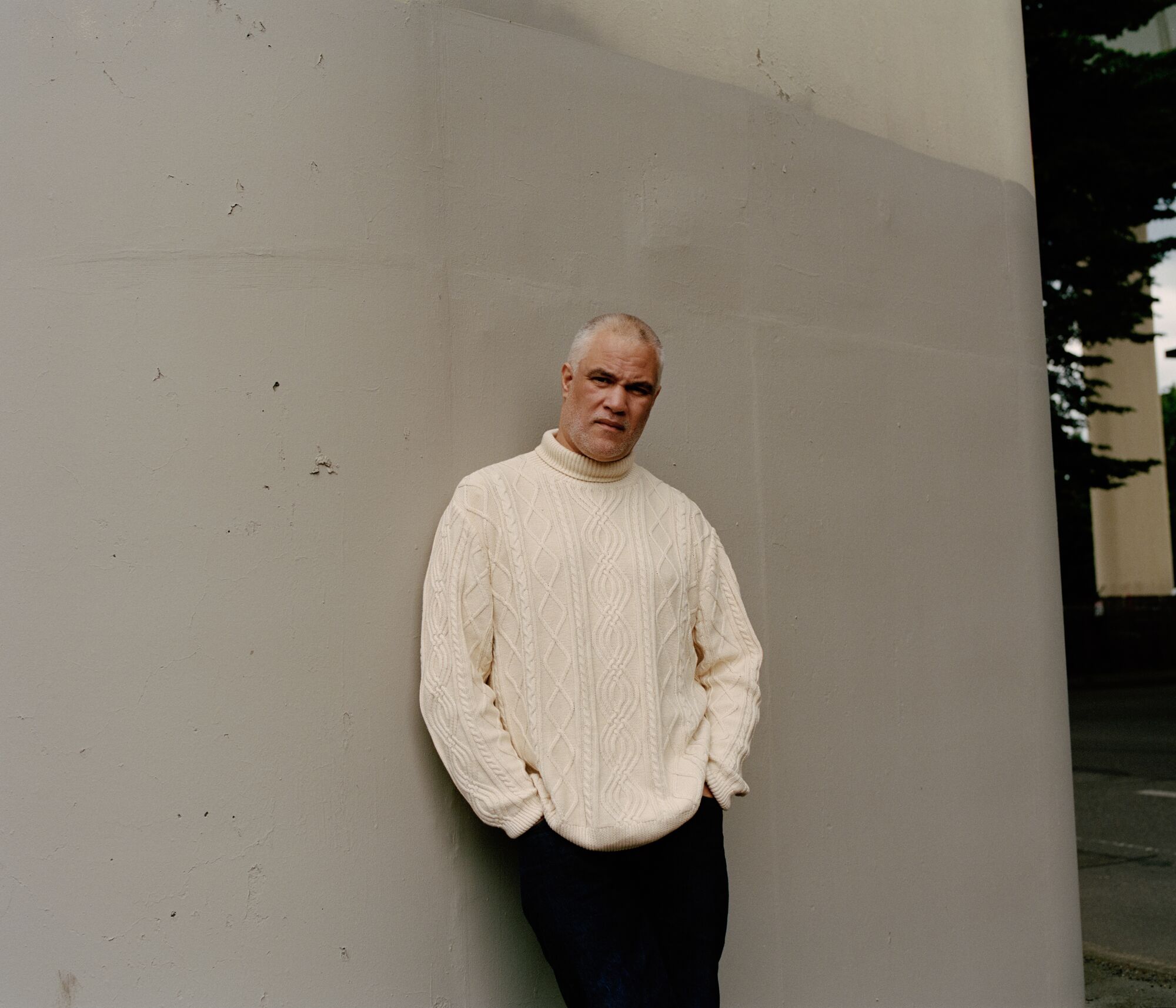 A portrait of Mat Johnson wearing a ribbed, white sweater.