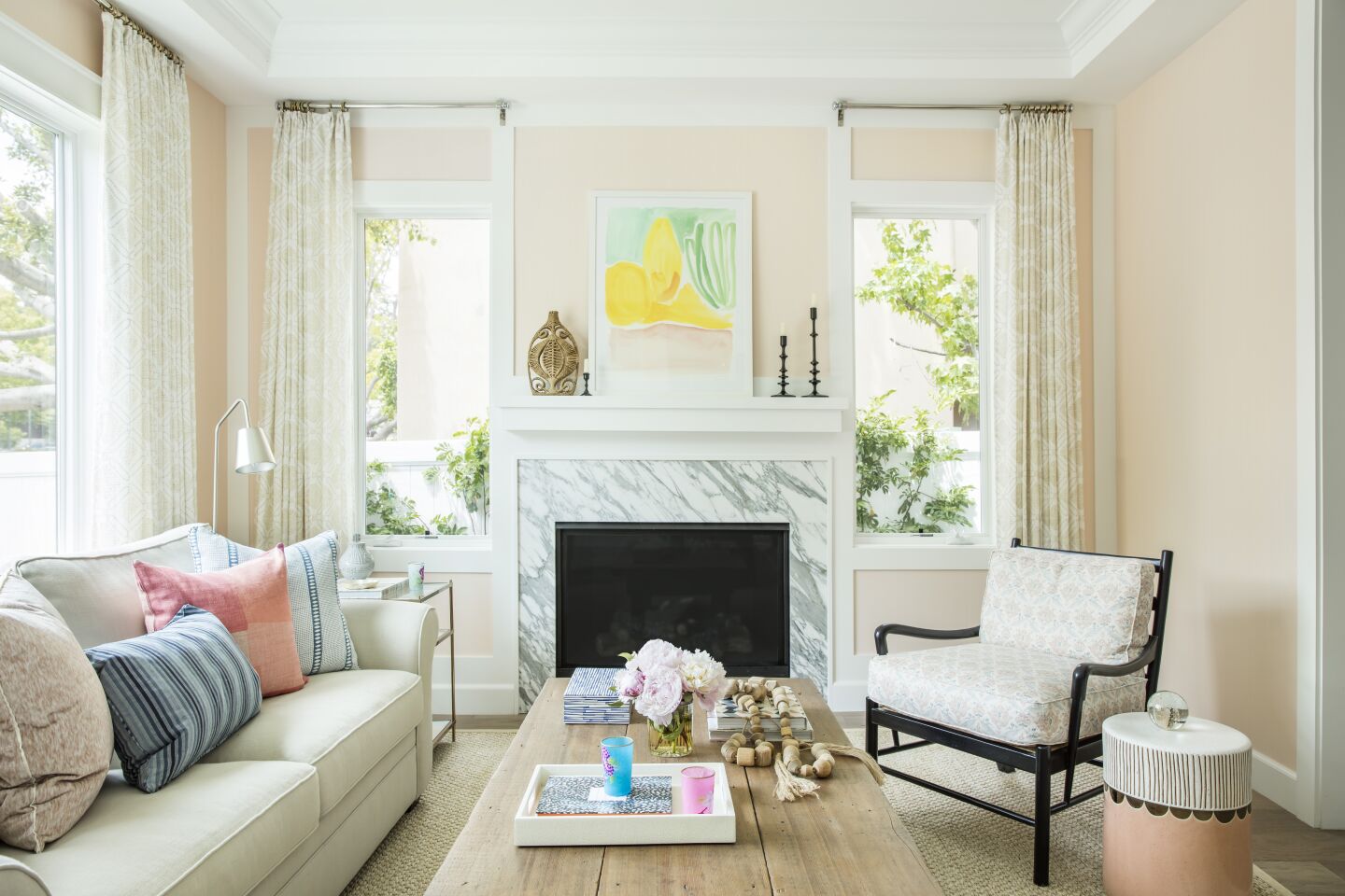 ... and after: Interior designer Christine Markatos Lowe painted the living room walls a dusty pink, added light-colored curtains in a geometric pattern and multicolored pillows, as well as furnishings to match the shade of Averyard's yellow Labrador, Indy.
