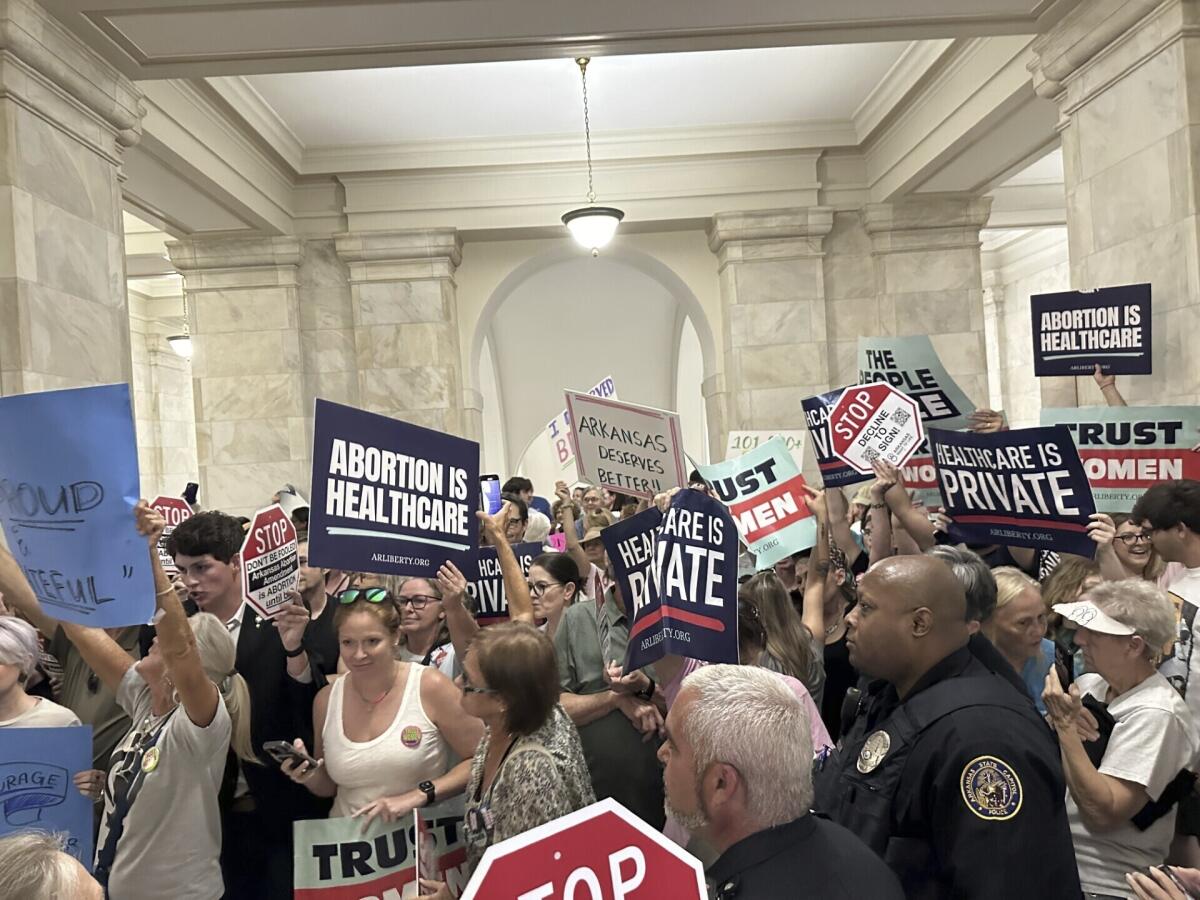 Supporters and opponents of abortion rights hold signs inside the Arkansas State Capitol building in Little Rock on July 5. 