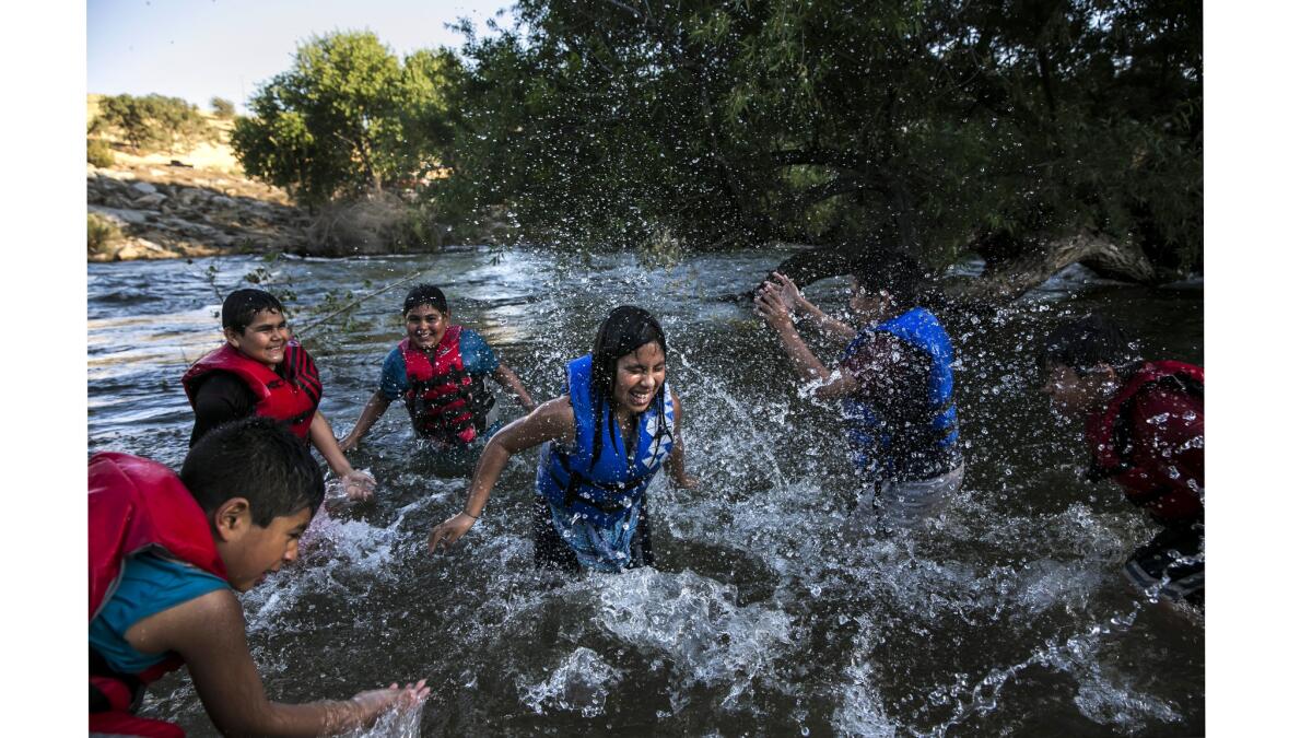 From left: Ramiro Rellano, 8; Alexander Quiroz, 10; Steve Arzate, 11; Xiomara Arellano, 10; Enrique Quiroz, 11; and Randy Arzate, 9, play in the water at Keyesville Camp.