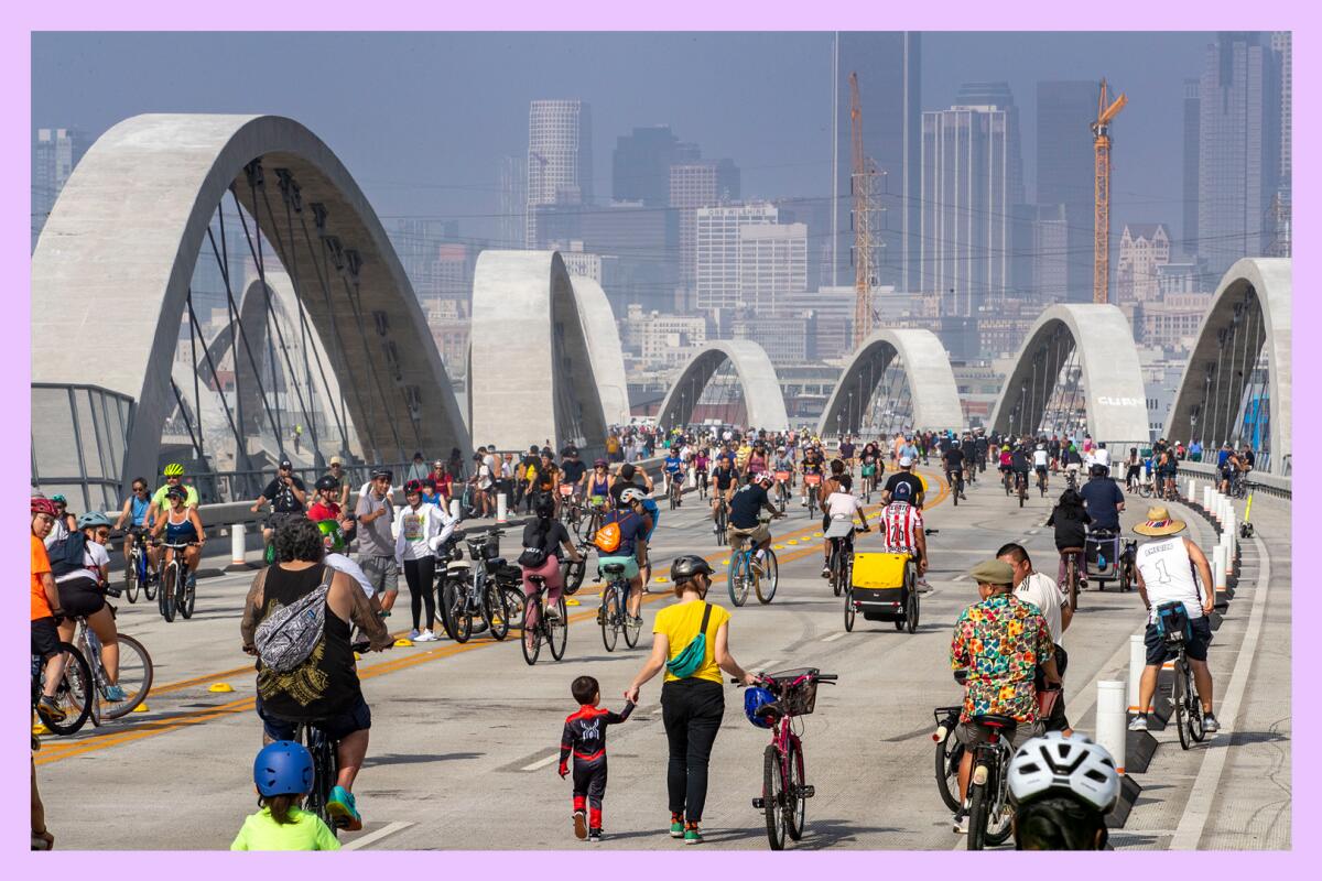 People walk and bike across a crowded bridge